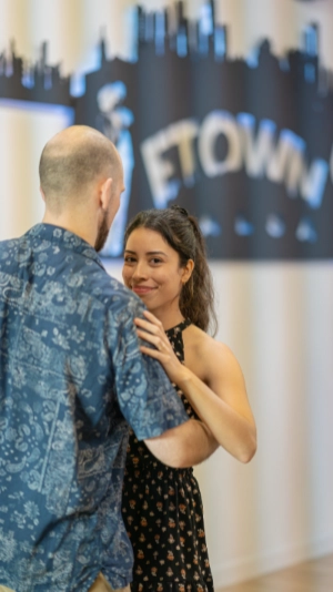 Couple dancing with ETOWN SALSA studio backdrop